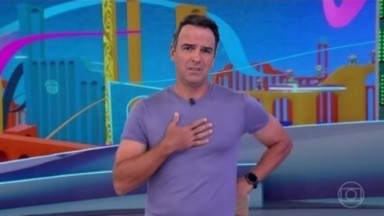Tadeu Schmidt de camiseta lilás, com a mão no peito e cara de sofrimento 