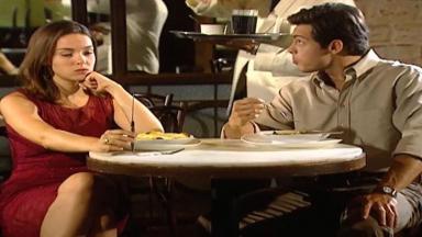 Cena de Laços de Família com Clara e Fred sentados num restaurante com cara de bravos 