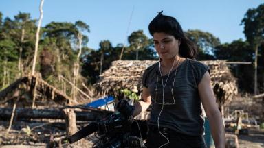 Danielle Zampollo no meio do Amazônia  segura material de reportagem 