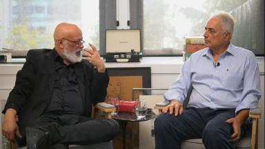 Luiz Felipe Pondé e William Waack sentados em cadeiras, durante a entrevista 