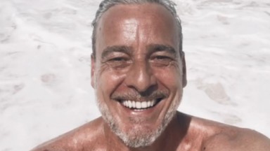 Alexandre Borges posa sorridente e sem camisa na praia para selfie postada no Instagram 