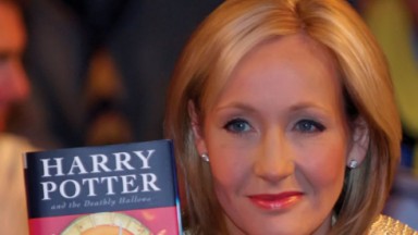  J.K. Rowling segurando o livro do Harry Potter 