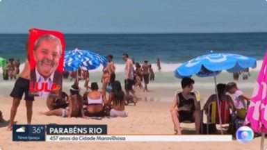Banhista levantando toalha com o rosto de Lula e as cores do PT em praia do Rio 