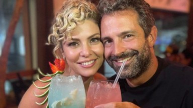 Bárbara Borges e Iran Malfitano sorrindo e posando com copos de drinks 