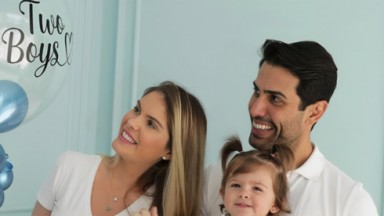 Bárbara Evans, Gustavo Theodoro e a filha olhando para balão escrito "two boys" 