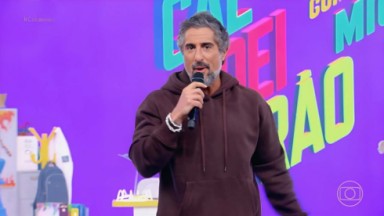 Marcos Mion segurando o microfone no palco do programa Caldeirão com Mion na Globo 