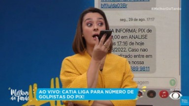 Catia Fonseca de roupa amarela falando ao telefone no Melhor da Tarde 