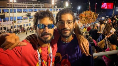 Thales Junqueira e Humberto Carrão posando para foto em sambódromo 