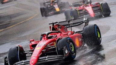 Carro vermelho em destaque em foto de corrida de Fórmula 1 