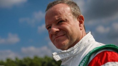 Rubens Barrichello com expressão pensativa, sem olhar para a câmera 