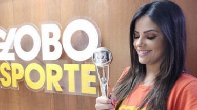 Carina Pereira segurando troféu conquistado por um quadro do Globo Esporte 