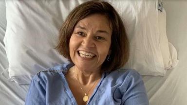 Claudia Rodrigues sorrindo em cama de hospital 