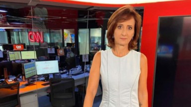 Thais Heredia de roupa branca e expressão séria em estúdio da CNN Brasil 