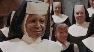Whoopi vestida de freira e sorrindo 