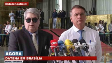 Datena ao lado de Jair Bolsonaro diante de microfones 