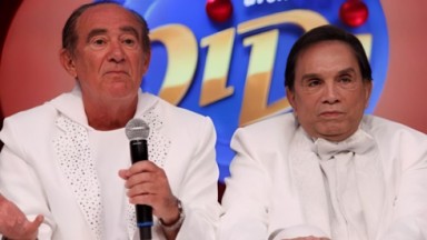 Renato Aragão e Dedé Santana de roupas brancas e expressões sérias 