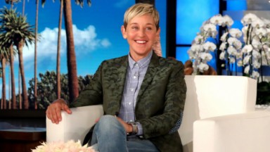 Ellen DeGeneres em seu programa sentada e sorrindo 