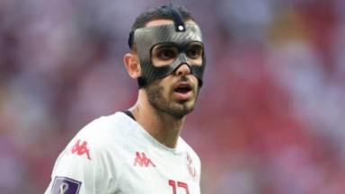 Jogador com máscara no rosto durante partida da Copa do Mundo 