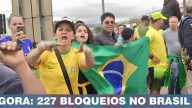 Manifestantes com bandeira do Brasil expulsando equipe da Band 