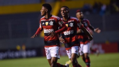 Jogadores do Flamengo correndo em campo e sorrindo 