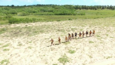 Imagem aérea dos participantes andando pela areia 