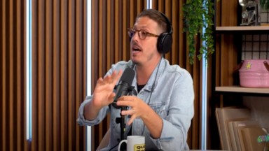 Fábio Porchat no podcast Quem Pode, Pod, de óculos de grau, com um microfone na sua frente 