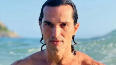 Jeff Machado posando na praia, com expressão séria e cabelos molhados 
