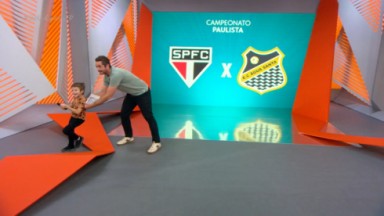 Felipe Andreoli empurrando seu filho no cenário do Globo Esporte 