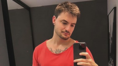 Felipe Neto de camiseta vermelha, sério, em foto no espelho 