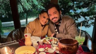Maiara e Fernando sorrindo perto de mesa com fondue 