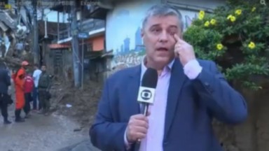 Flávio Fachel emocionado em Petrópolis, segurando microfone da Globo 