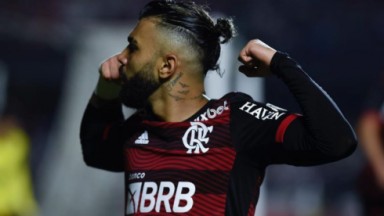 Gabigol em campo erguendo os braços com camisa do Flamengo 