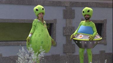 Sarah e Gilberto fantasiados de alienígenas no gramado do BBB21 