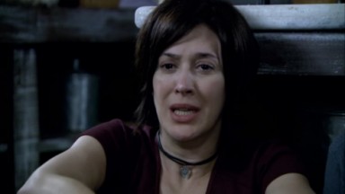 Claudia Raia como Donatela em A Favorita. Ela está sentada na cozinha do restaurante do Pep 
