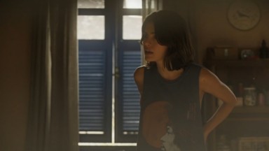 Julia Dalavia como Guta em Pantanal. Ela está no quarto da Maria Bruaca 