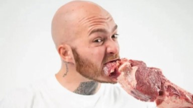 Homem comendo carne crua 