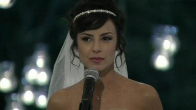 Cena de Império com Maria Clara vestida de noiva diante de um microfone 