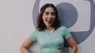 Jade Picon sorrindo com logo da Globo na parede 