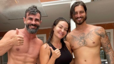 Laura Keller posando entre o ex, Jorge Sousa, e o atual, Gustavo Saad. Os três sorrindo. 