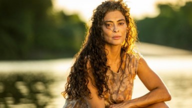 Juliana Paes caracterizada como Maria Marruá na beira de rio posando para foto com expressão séria 