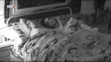 Juliette e Fiuk estão deitados no escuro na cama de casal do quarto cordel do BBB21 enquanto a sister faz carinho no rosto do brother 
