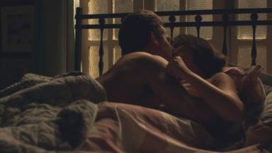 Júlio e Antônia se beijando na cama 