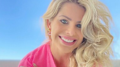 Karina Bacchi sorri para fotos usando roupa rosa 