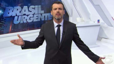 Lucas Martins de braços abertos no palco do Brasil Urgente 