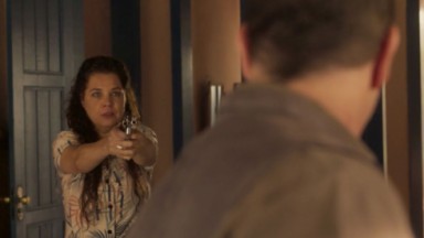 Maria Bruca (Isabel Teixeira) em momento de raiva contra Tenório (Murilo Benício): ela mira arma em direção ao marido 