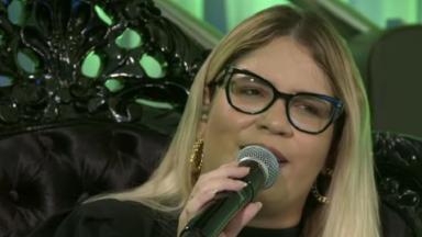 Marília Mendonça cantando de óculos 