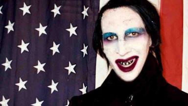 Marilyn Manson posado para foto, ao lado da bandeirados Estados Unidos 