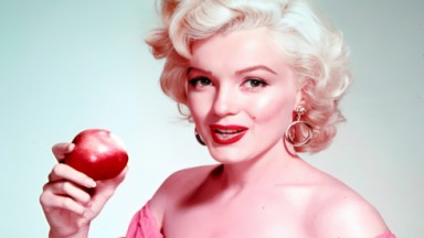 Marilyn Monroe segurando uma maçã em foto posada 