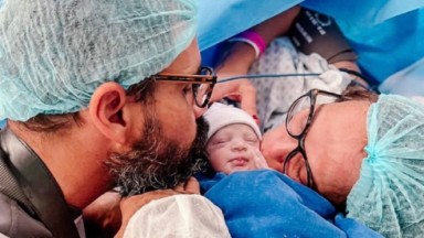  Juliano Cazarré e Letícia Cazarré beijam a filha Maria Guilhermina após o parto  