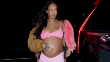 Rihanna grávida, com a mão na barriga, vestindo roupa cor de rosa 